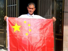 2019年9月22日，江苏省海安市大公镇王院村，村民王世彬正在屋顶升国旗。今年75岁的王世彬从2011年开始，9年来，每天坚持在屋顶升国旗，放国歌，已更换40多面国旗。