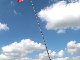 他坚持不懈，每天爬上楼顶，把国旗穿在竹杆上，竖起来，向国旗敬礼。